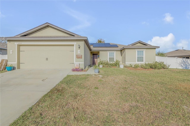 ranch-style home with a garage, a front yard, and solar panels