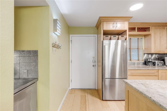 kitchen with plenty of natural light, light hardwood / wood-style floors, light brown cabinetry, and stainless steel refrigerator