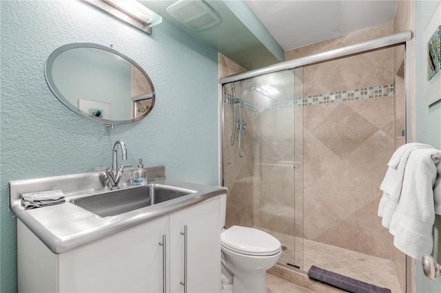 bathroom featuring vanity, toilet, and a shower with shower door