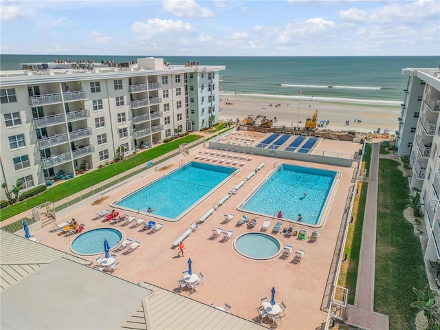 view of pool with a water view and a view of the beach