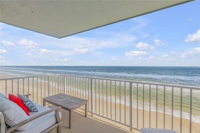 balcony featuring a view of the beach and a water view