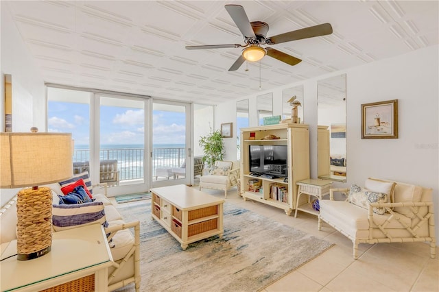 tiled living room with ceiling fan and expansive windows