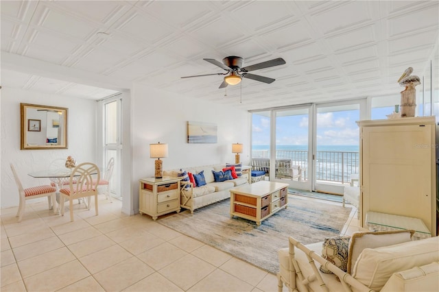 living room featuring light tile patterned floors, a water view, expansive windows, and ceiling fan