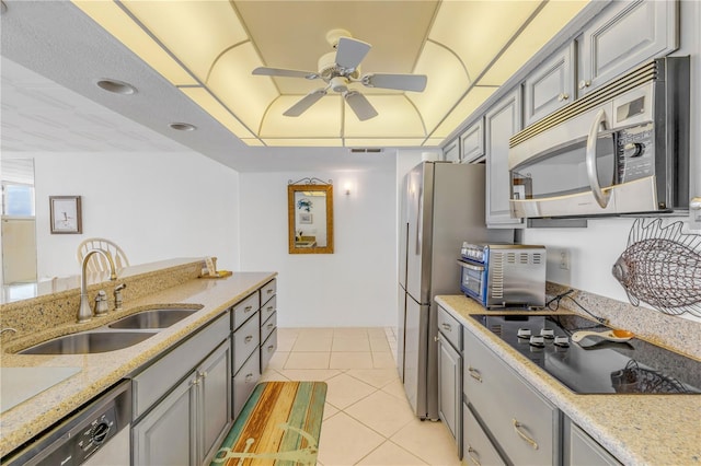 kitchen with gray cabinets, sink, light tile patterned floors, and appliances with stainless steel finishes