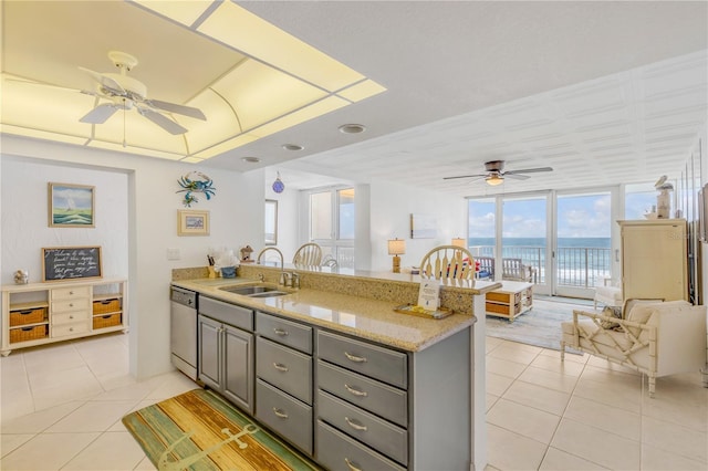 kitchen with stainless steel dishwasher, expansive windows, light tile patterned floors, a water view, and gray cabinets