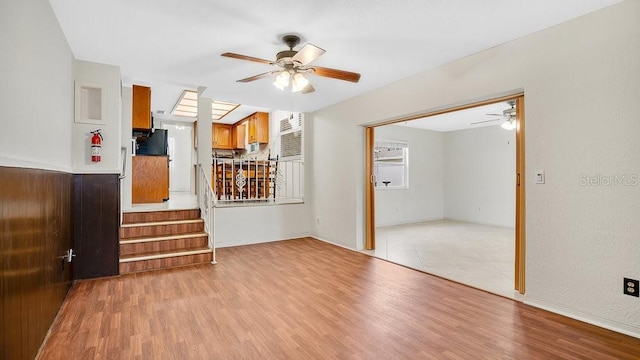 unfurnished living room featuring light wood-type flooring and ceiling fan