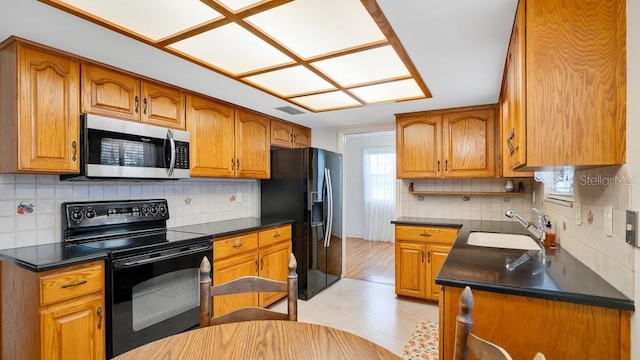 kitchen featuring sink, backsplash, and black appliances