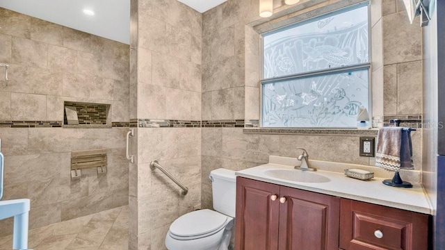 bathroom featuring toilet, tile walls, tiled shower, and vanity