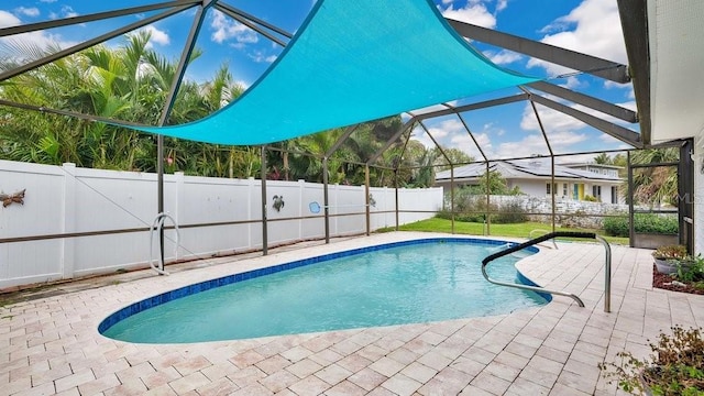 view of swimming pool with glass enclosure and a patio