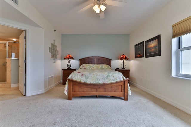 carpeted bedroom featuring ceiling fan and ensuite bath