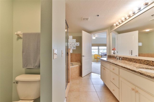 bathroom featuring vanity, tile patterned floors, ceiling fan, a textured ceiling, and tiled tub