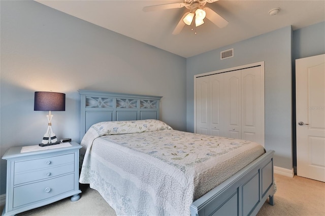 bedroom featuring ceiling fan, light carpet, and a closet