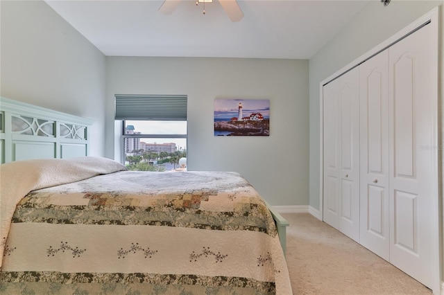 carpeted bedroom featuring ceiling fan and a closet