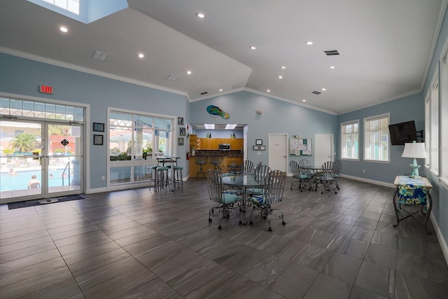 dining area with high vaulted ceiling, plenty of natural light, and crown molding