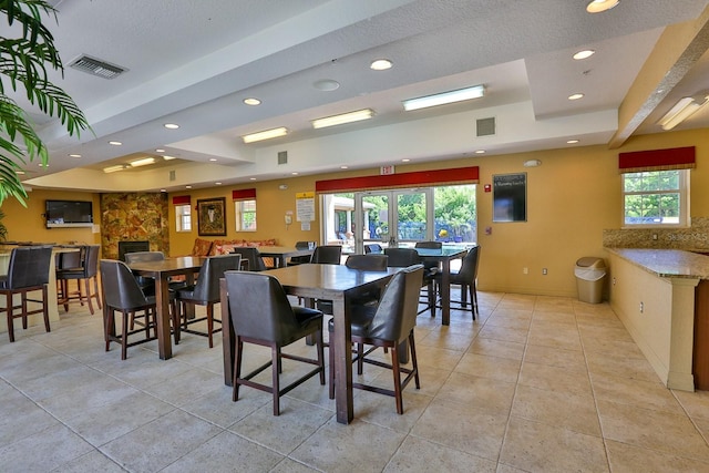 dining area featuring a fireplace and light tile patterned floors