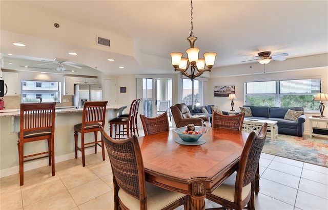 tiled dining area featuring ceiling fan with notable chandelier