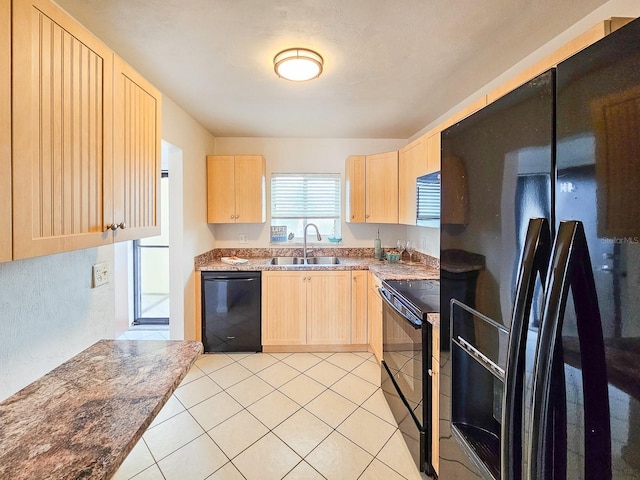 kitchen featuring black appliances, light tile patterned floors, sink, and light brown cabinetry