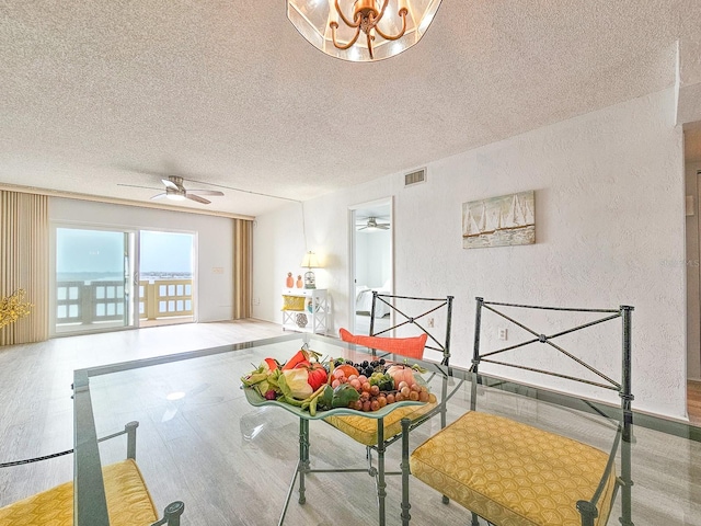 interior space with ceiling fan, light hardwood / wood-style floors, and a textured ceiling