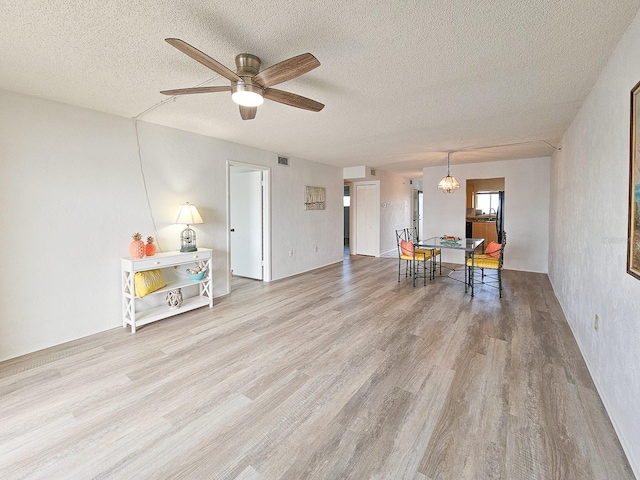 3606 S Peninsula Dr Unit 404, Port Orange, FL 32127 - living room featuring wood finished floors, a ceiling fan, and a textured ceiling