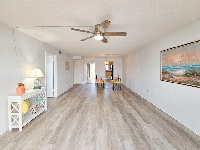 interior space featuring ceiling fan, a textured ceiling, and light wood-type flooring