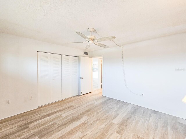 3606 S Peninsula Dr Unit 404, Port Orange, FL 32127 - unfurnished bedroom with light wood-type flooring, a closet, and a ceiling fan