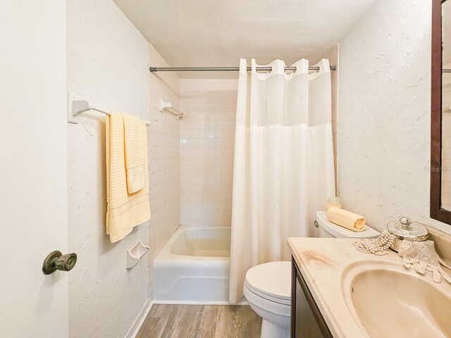 3606 S Peninsula Dr Unit 404, Port Orange, FL 32127 - bathroom featuring wood finished floors, vanity, shower / tub combo, and a textured wall