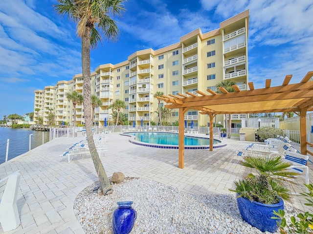 view of swimming pool featuring a pergola and a water view