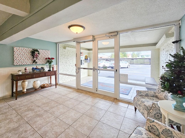 3606 S Peninsula Dr Unit 404, Port Orange, FL 32127 - doorway with tile patterned floors, a wainscoted wall, and a textured ceiling