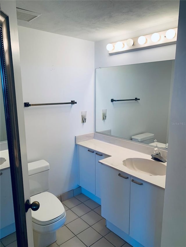 bathroom featuring tile patterned floors, vanity, and toilet