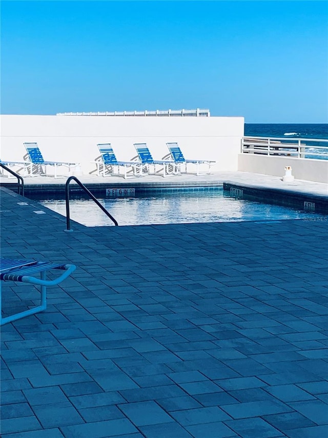 view of swimming pool featuring a water view