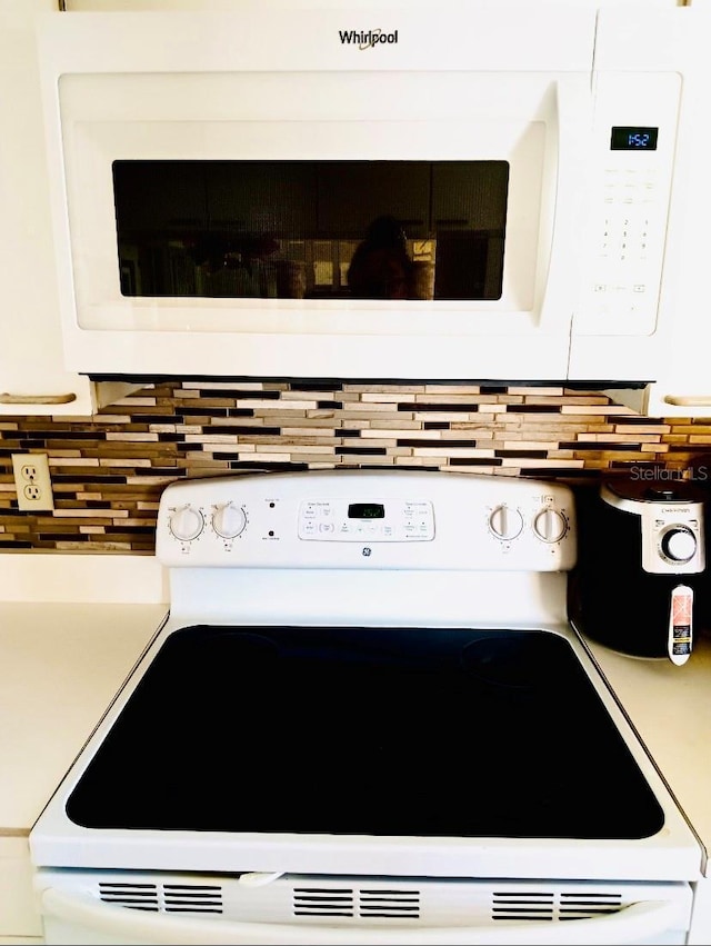 details with white cabinets, white appliances, and backsplash