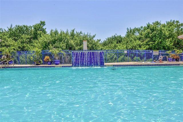 view of swimming pool with pool water feature