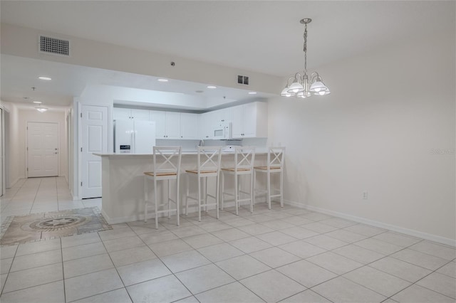 kitchen with white cabinetry, kitchen peninsula, white appliances, a kitchen bar, and light tile patterned flooring