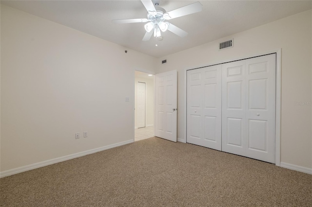 unfurnished bedroom featuring ceiling fan, a closet, and light colored carpet