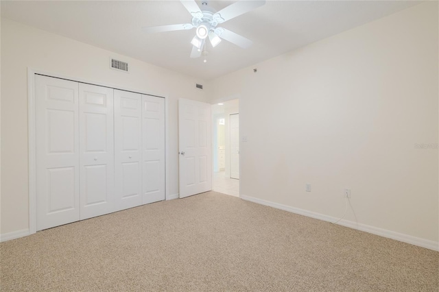 unfurnished bedroom featuring carpet, a closet, and ceiling fan