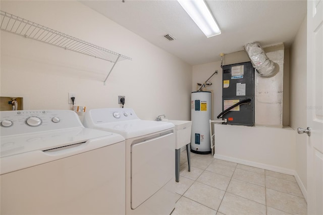 clothes washing area with heating unit, sink, water heater, light tile patterned floors, and washing machine and clothes dryer