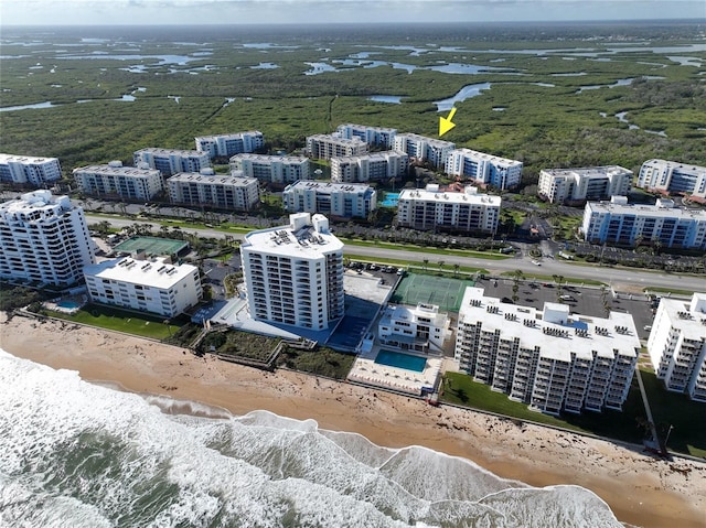 birds eye view of property featuring a beach view and a water view