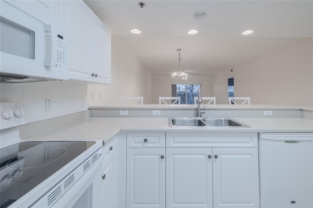 kitchen featuring sink, white cabinets, and white appliances