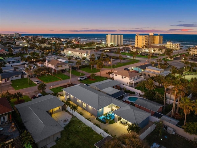 aerial view at dusk featuring a water view