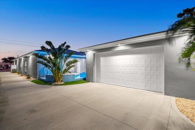 view of garage at dusk