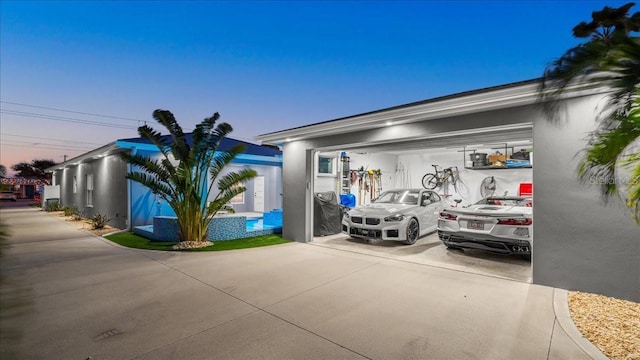 view of garage at dusk