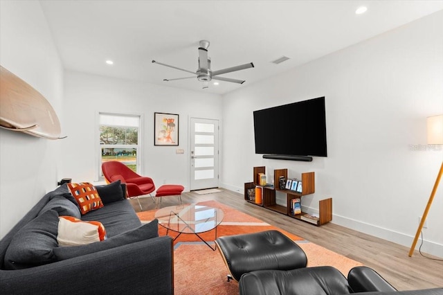 living room featuring light hardwood / wood-style flooring and ceiling fan