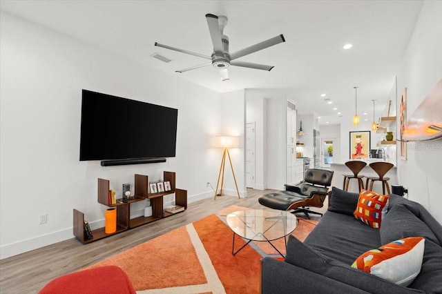 living room with light hardwood / wood-style flooring and ceiling fan