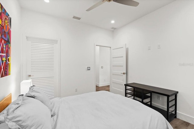 bedroom with a closet, ceiling fan, and dark hardwood / wood-style flooring