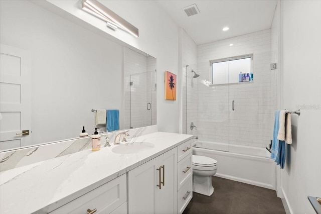 full bathroom featuring vanity, bath / shower combo with glass door, and toilet