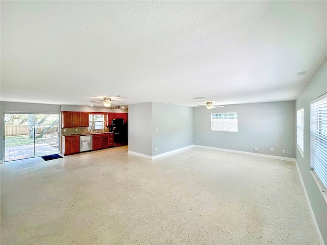 unfurnished living room with ceiling fan, a textured ceiling, and a wealth of natural light