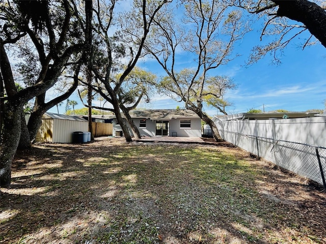 view of yard with a storage shed and a patio