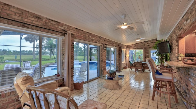 sunroom / solarium featuring ceiling fan, lofted ceiling, and wooden ceiling