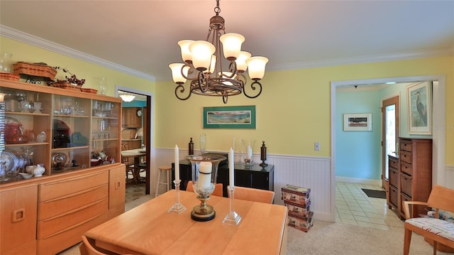 carpeted dining area featuring a notable chandelier and ornamental molding