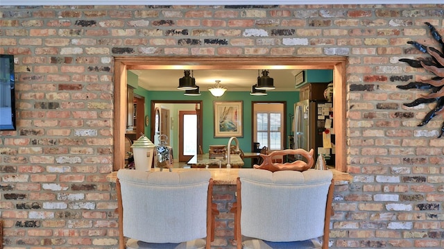 living room with ornamental molding and brick wall